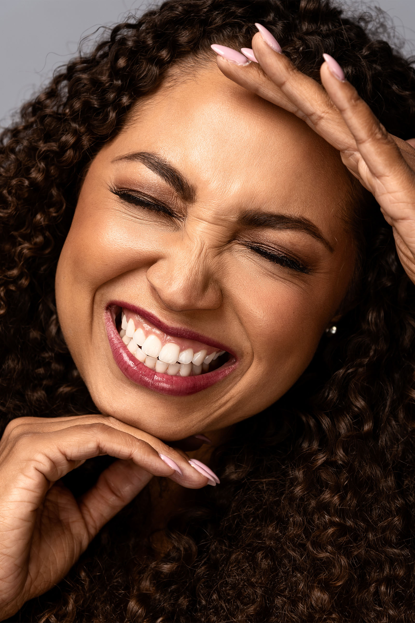 Female model closeup smiling, eyes closed, featuring sophisticated makeup by Utah photographer Christopher Loke