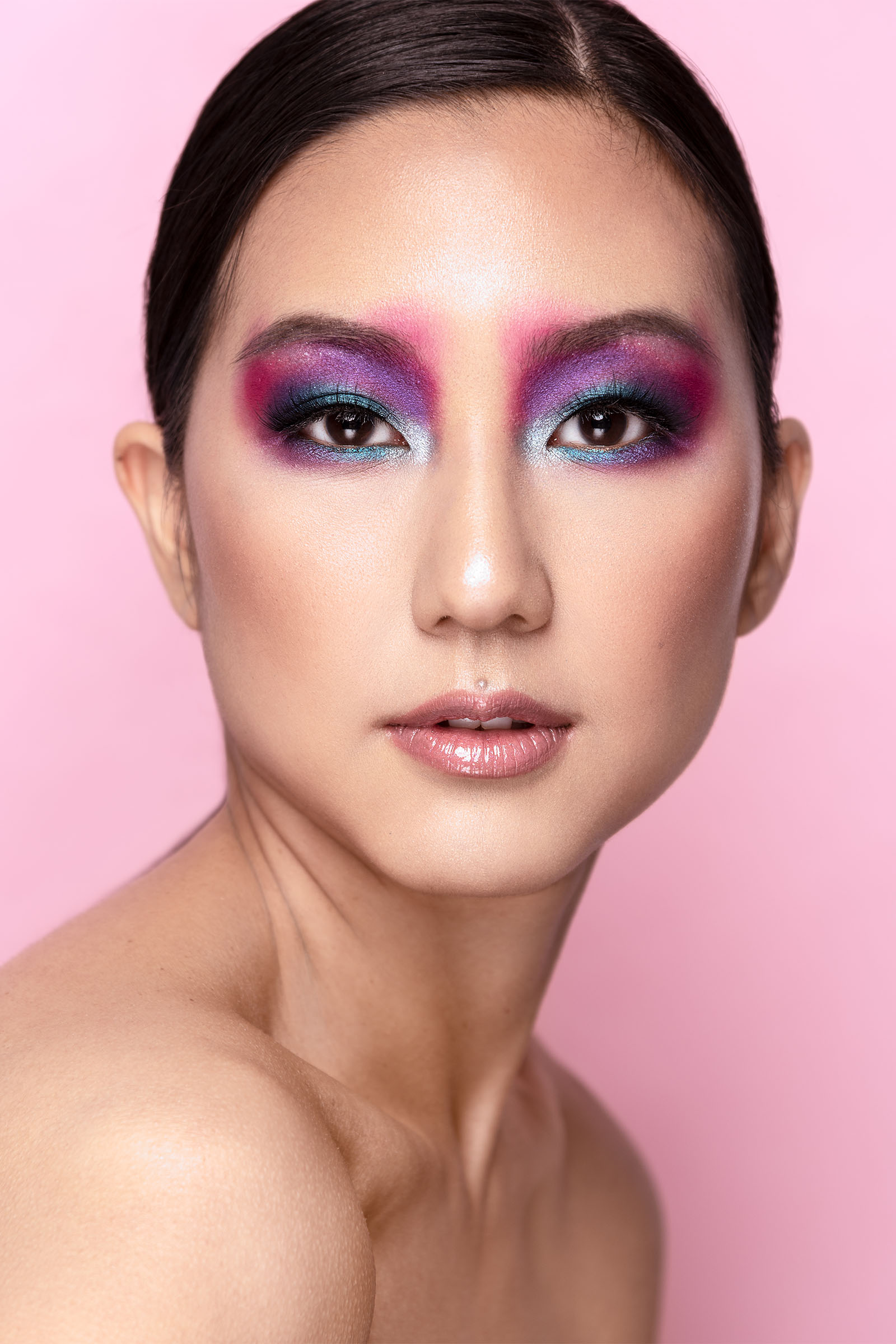 Beauty portrait of Asian female model with bright colorful eyeshadow and pastel lips, hair pulled back, long neck by Utah photographer Christopher Loke