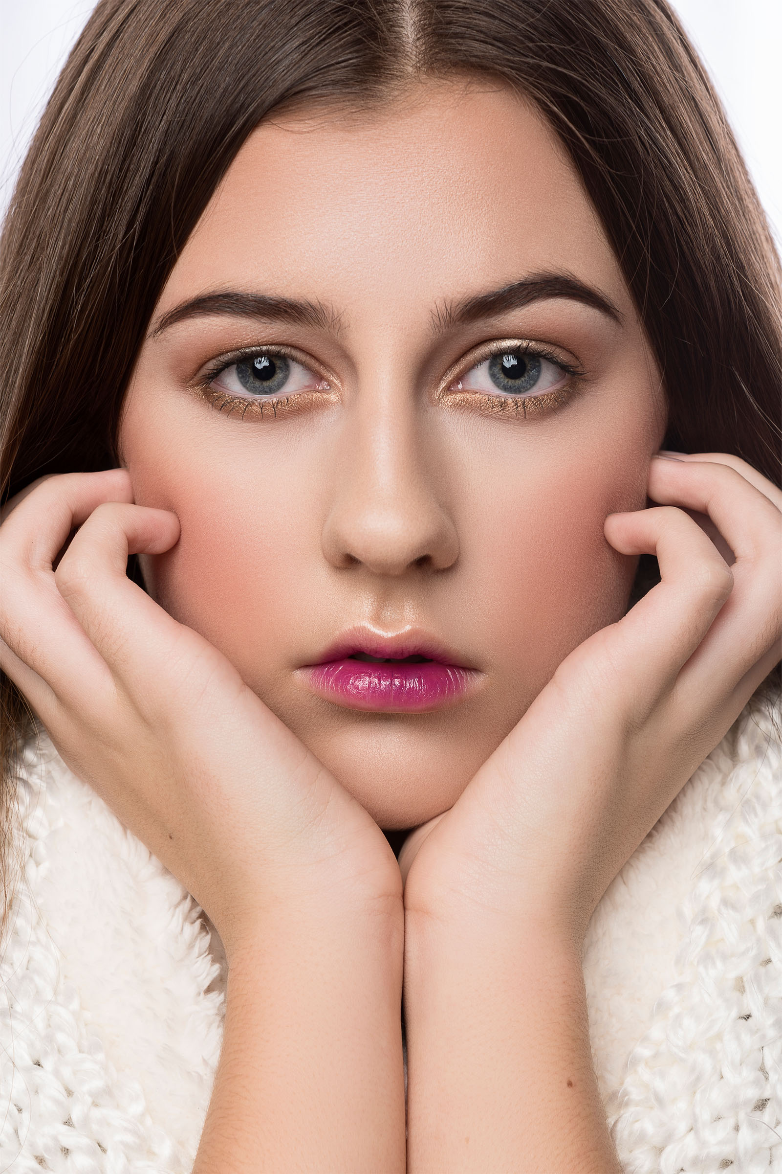 Beauty portrait of a female juvenile model, hands propping her chin and face, clean, pastel makeup with red lips, looking at the camera